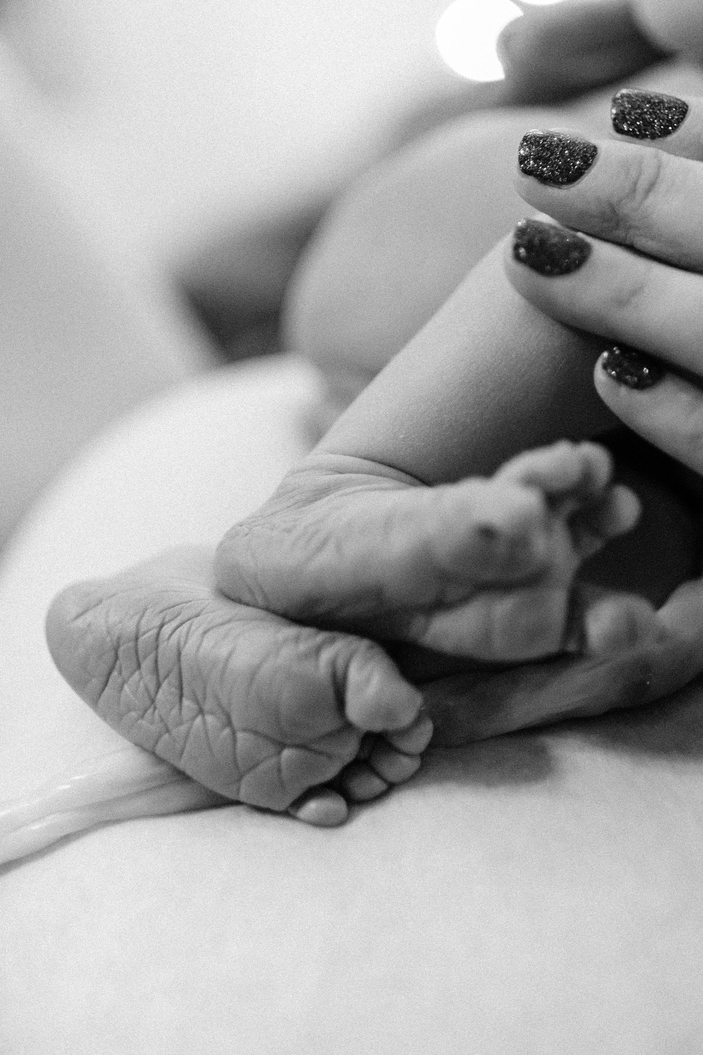 Newborn feet held in gentle hands